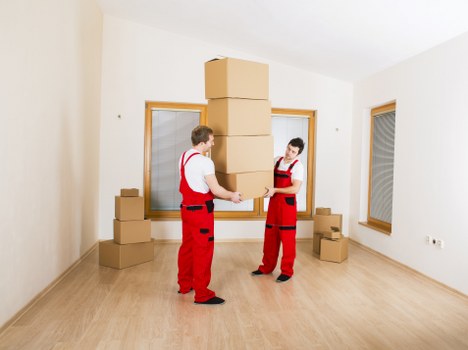 Local movers unloading boxes into a Bermondsey apartment building